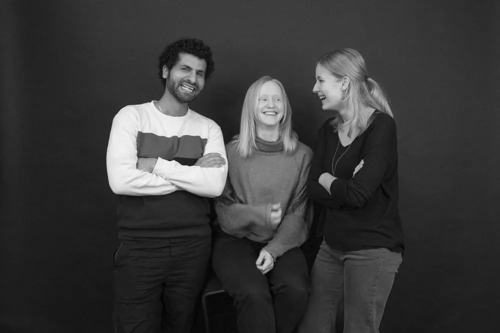 Drei Personen, die sich gegenüberstehen und anlachen